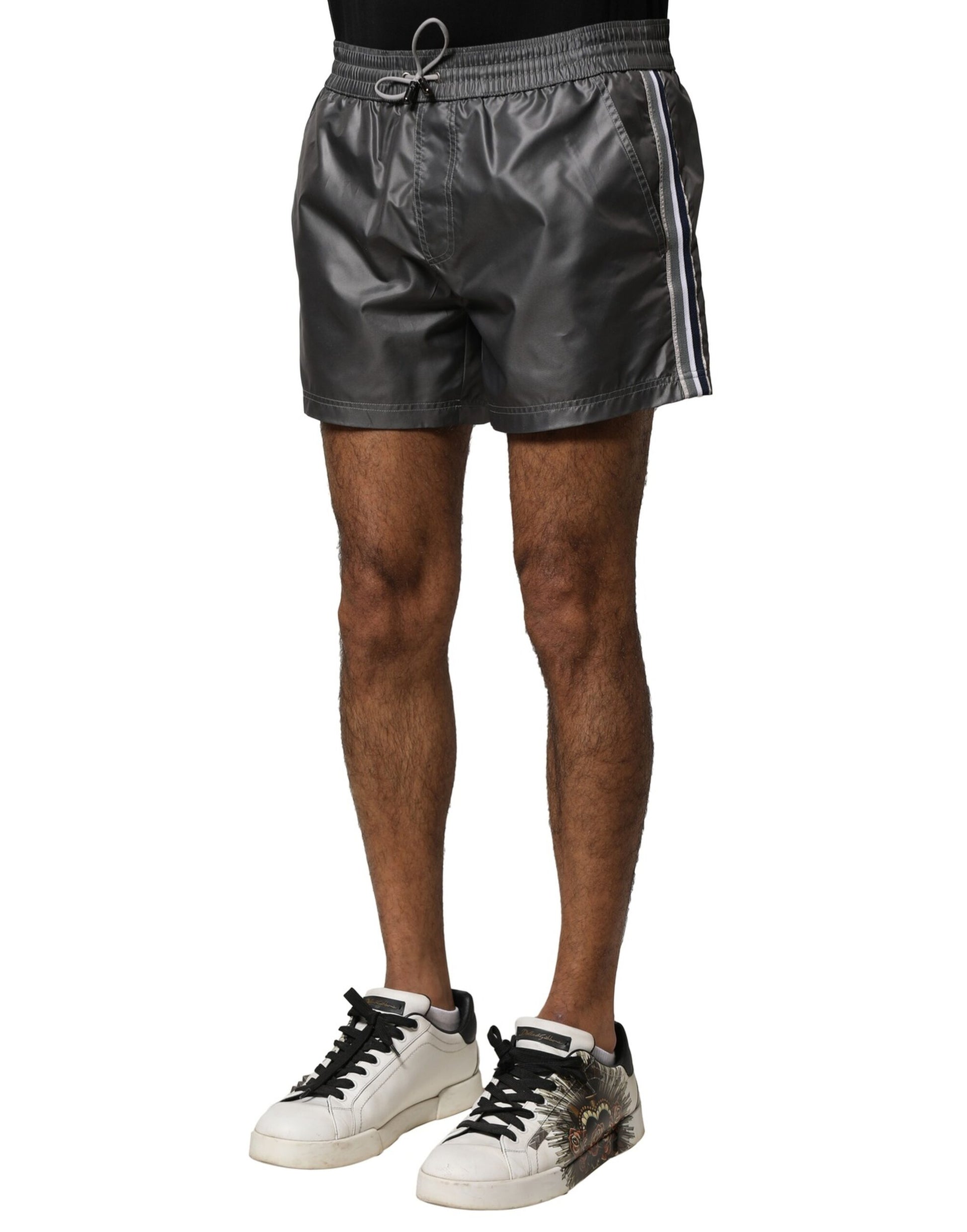 Man wearing black sneakers and gray shorts
