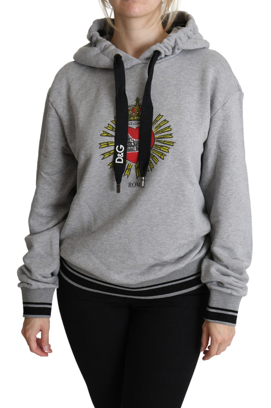 Woman wearing gray hoodie with graphic design on front