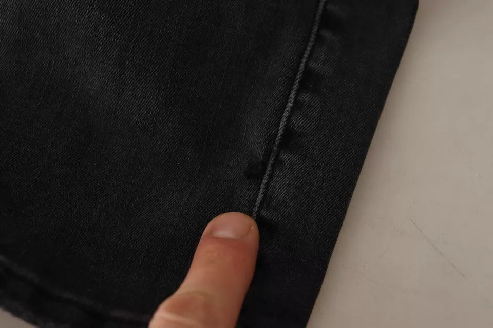 Hand pointing to a zipper on jeans