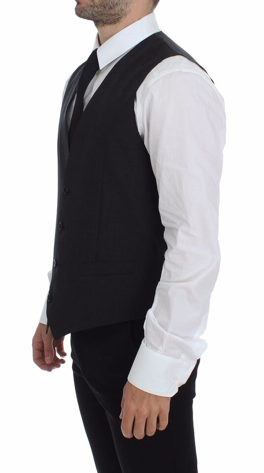 A mannequin wearing a gray vest with black buttons and white shirt