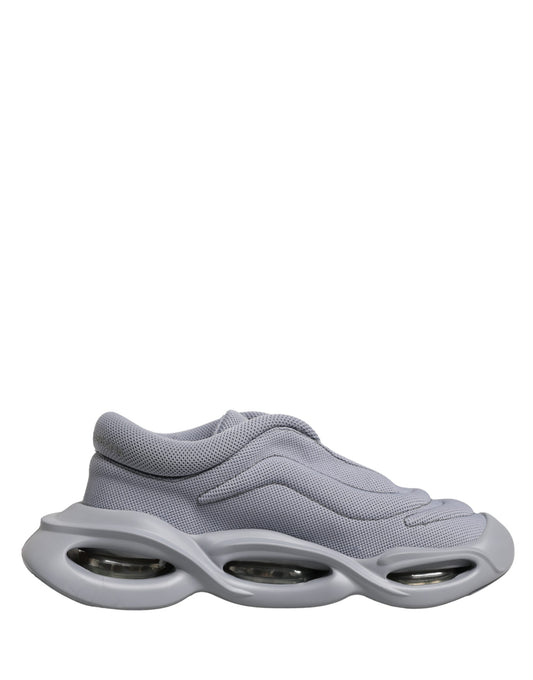 A pair of gray slip-on shoes with a wave design on the sole