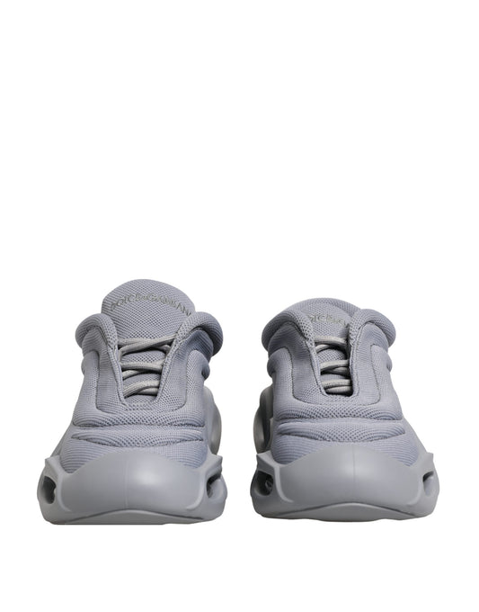 Pair of gray slip-on shoes with laces, featuring a low top and a wave design on the side