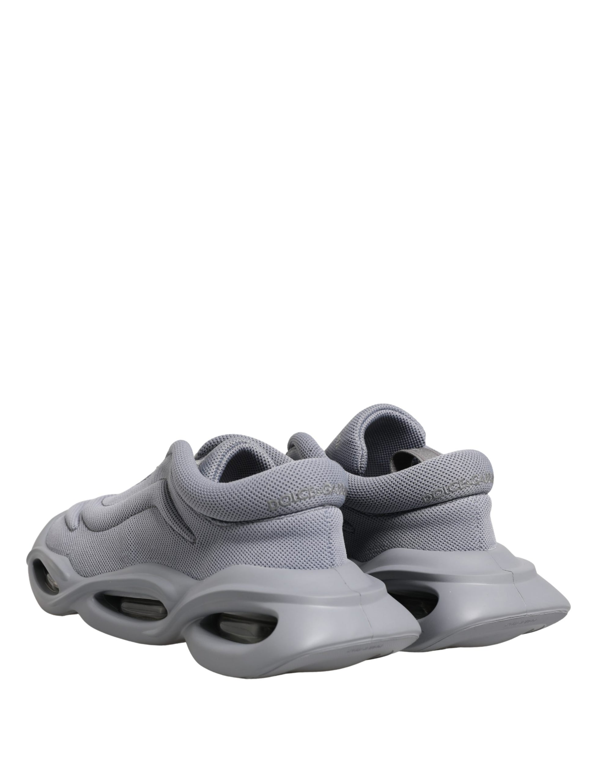 Pair of gray slip-on shoes with white soles, featuring a textured upper and the brand's logo on the side