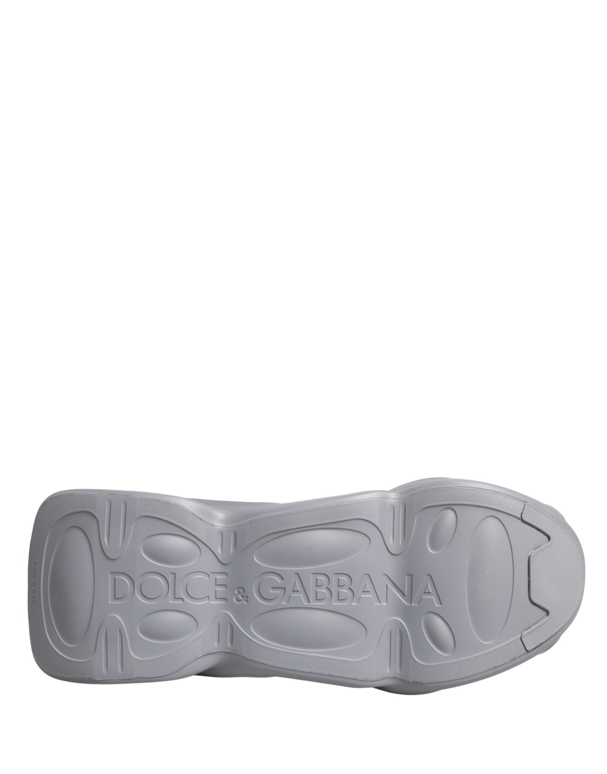 A gray slip-on shoe with a wave design on the side, featuring the brand name "Dolce & Gabbana" on the heel