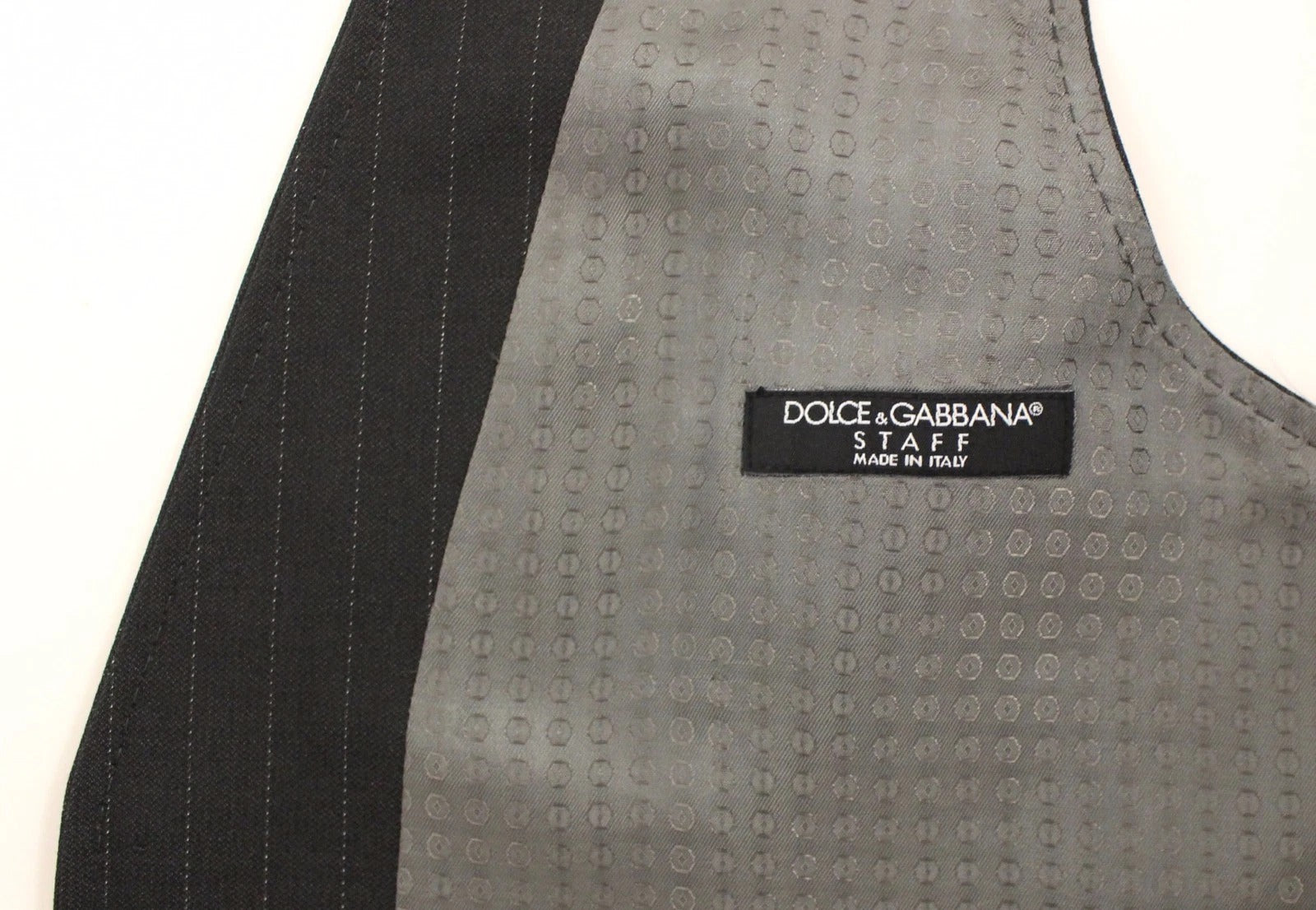 A gray striped vest with a black and white label on the back