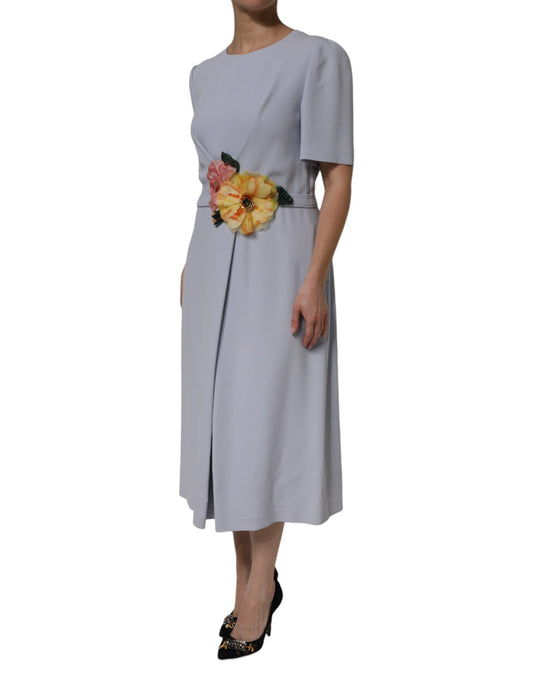 Woman wearing a long sleeve dress with a floral belt