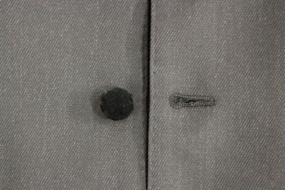A gray wool vest with a black button