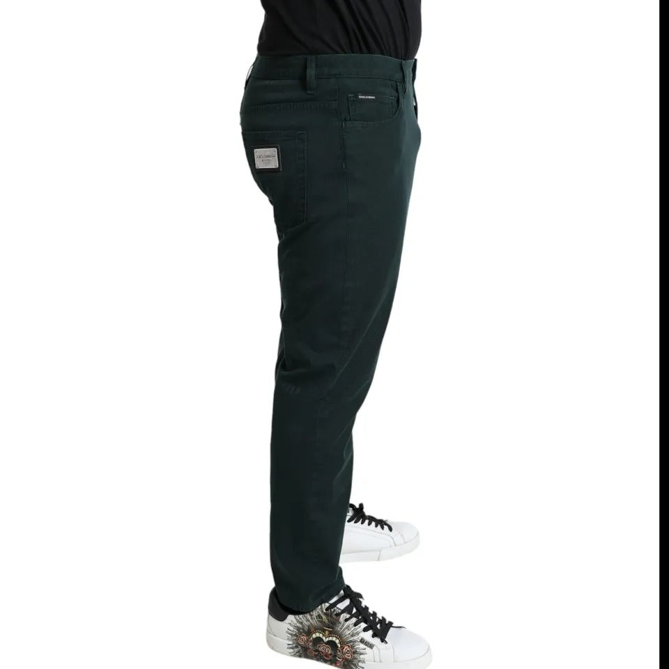 Person wearing dark pants and sneakers standing against white background