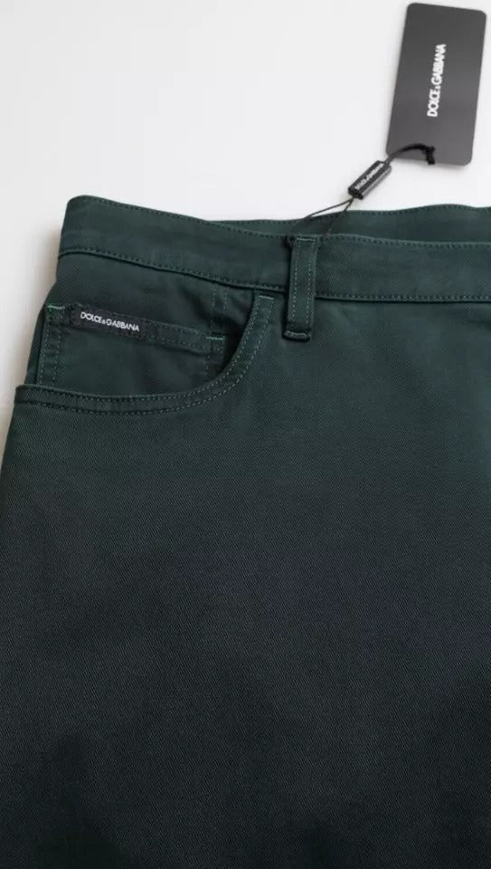 Pair of dark green pants hanging on a white background