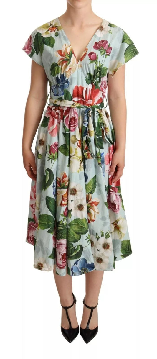 A woman wearing a green floral dress with short sleeves and a V-neck