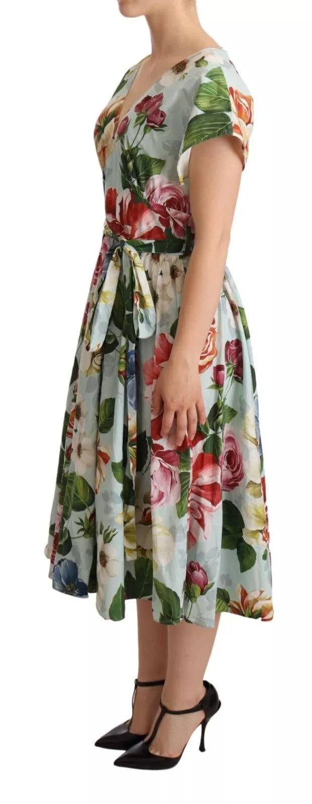 A woman wearing a green floral dress with short sleeves and a V-neck