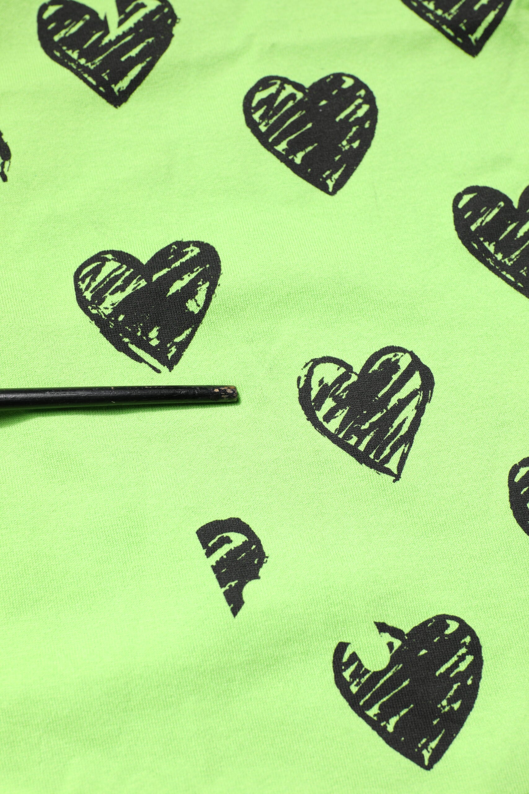 Green fabric with black hearts