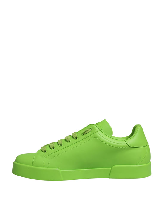 A pair of green leather sneakers with a low top, featuring a lace-up design and a chunky sole