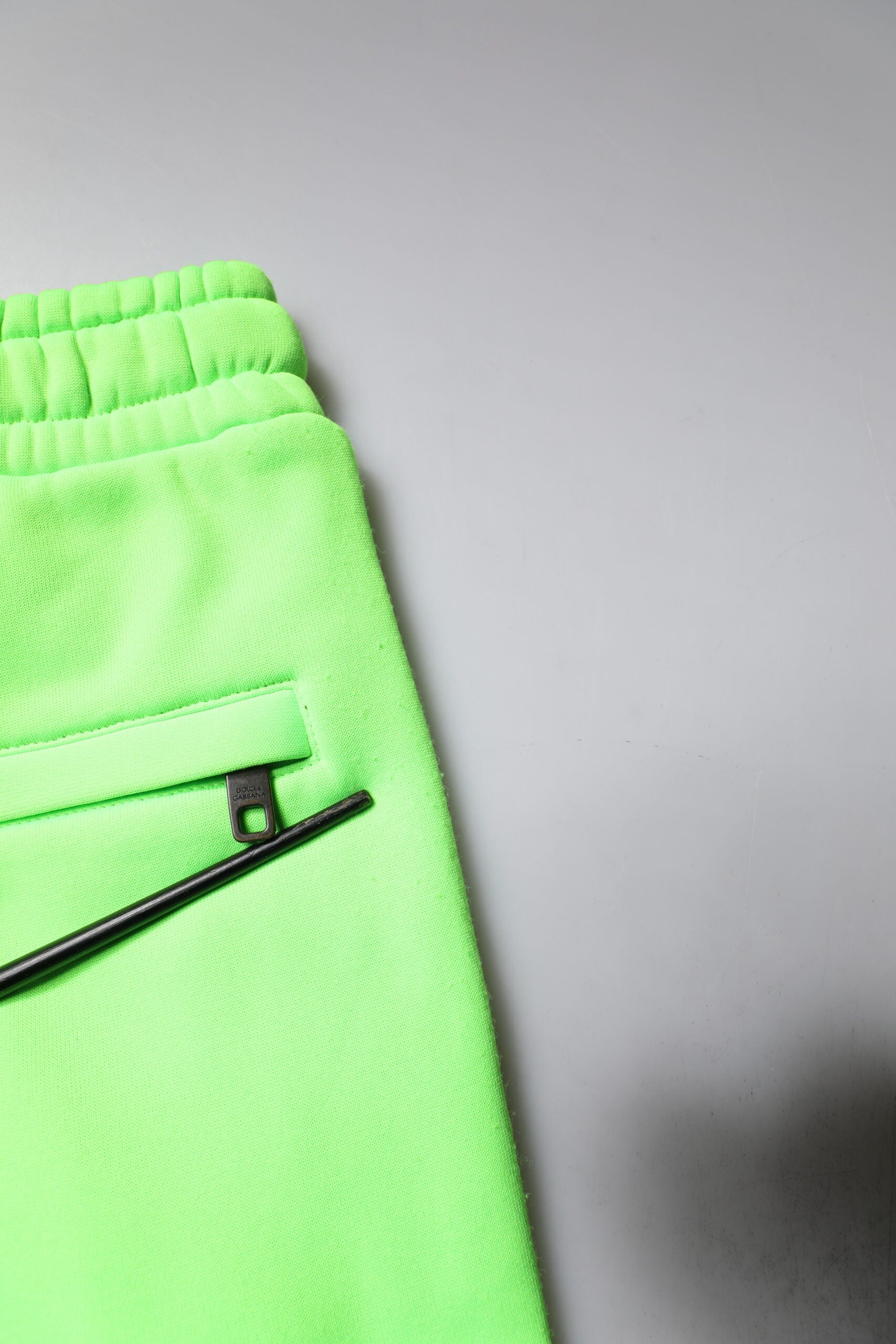 A pair of green camouflage cargo shorts with a patchwork design, featuring a metal button closure