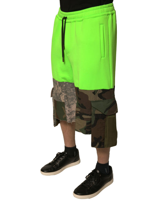 A pair of green patchwork cargo bermuda shorts with black laces and a black logo on the left leg