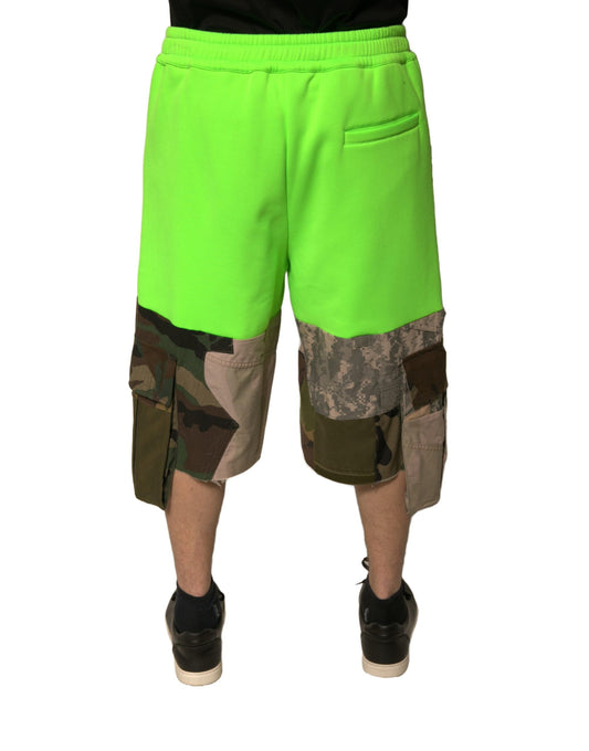 A pair of green cargo shorts with patchwork design, featuring a camouflage pattern on the lower legs