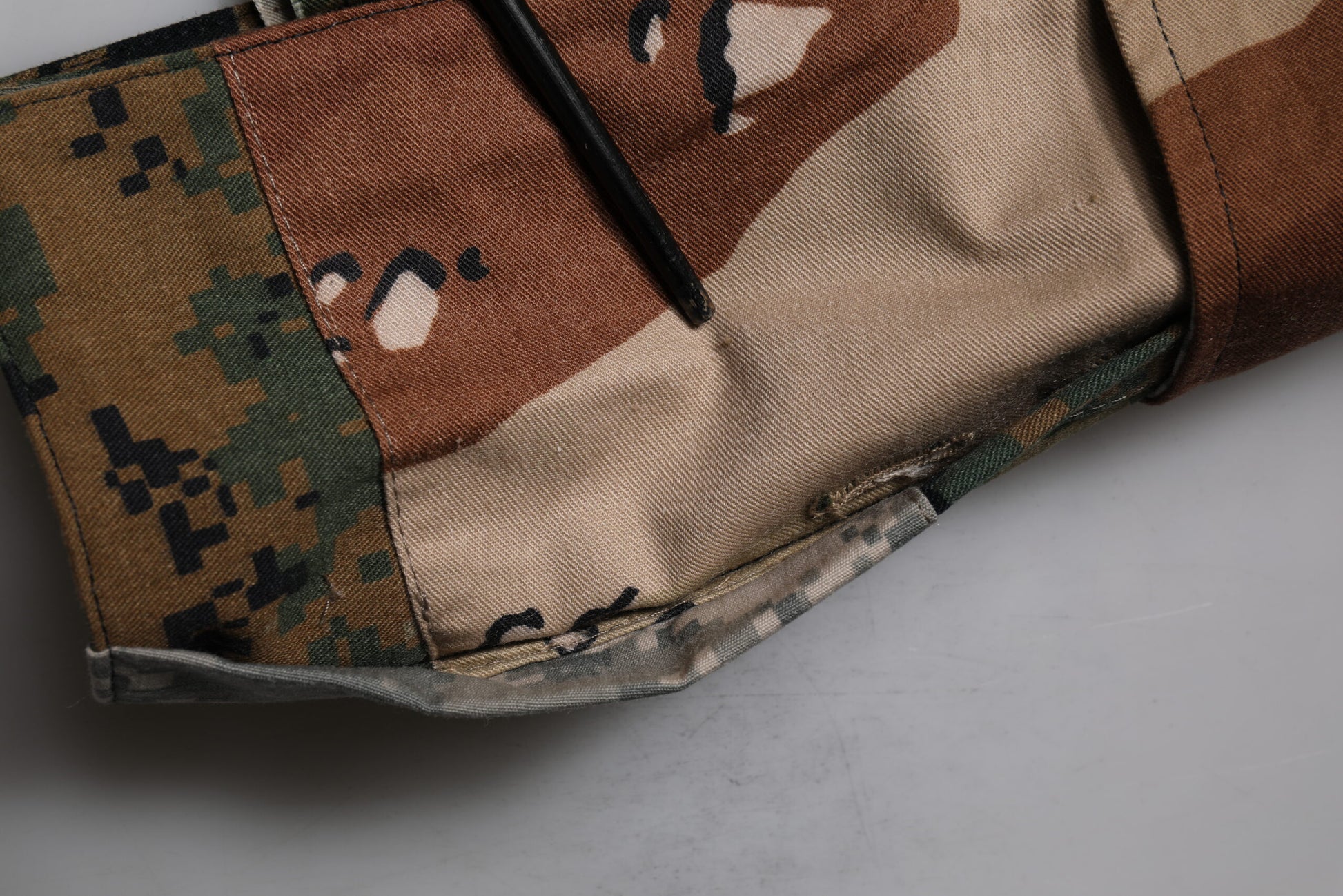 Camouflage pattern cargo shorts with patches of green, brown and black fabric