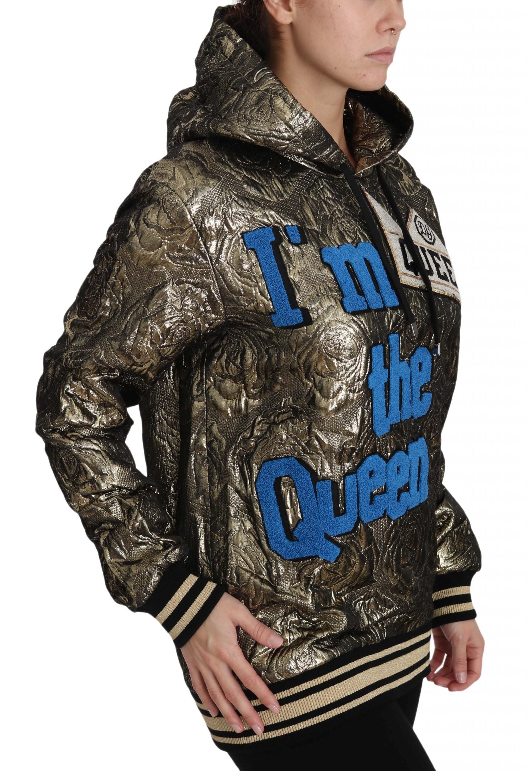 Woman wearing a gold jacket with "I'm the Queen" written on it