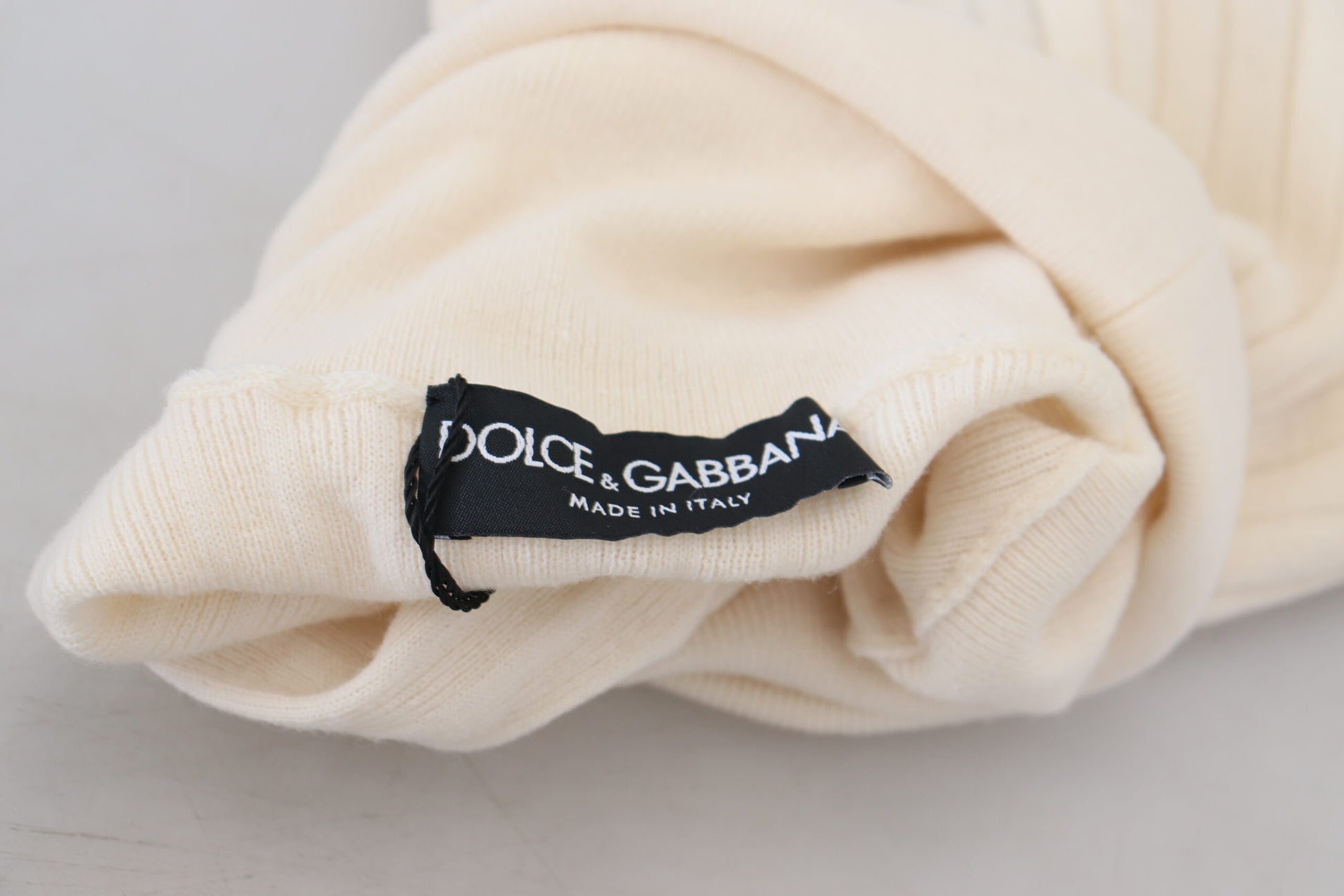 Yellow folded clothing item with black label reading "dolce & gabbana"