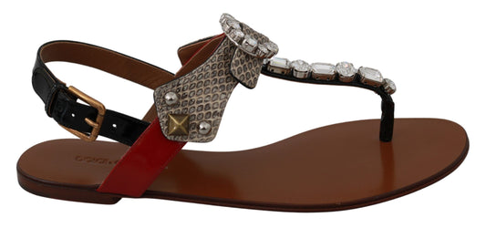 Pair of women's sandals with embellishments and a red strap