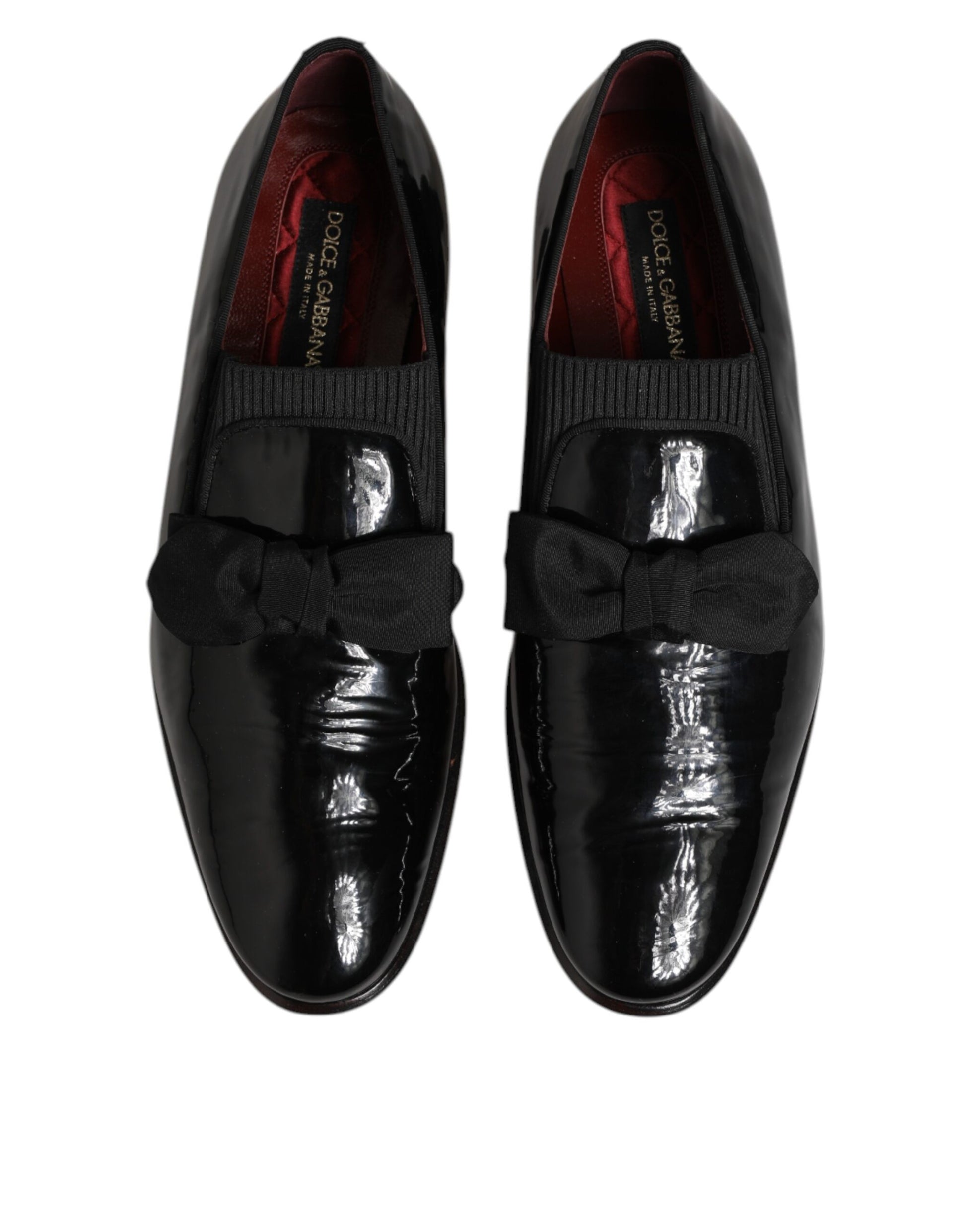Black leather loafers with red lining, featuring a bow tie design on the vamp