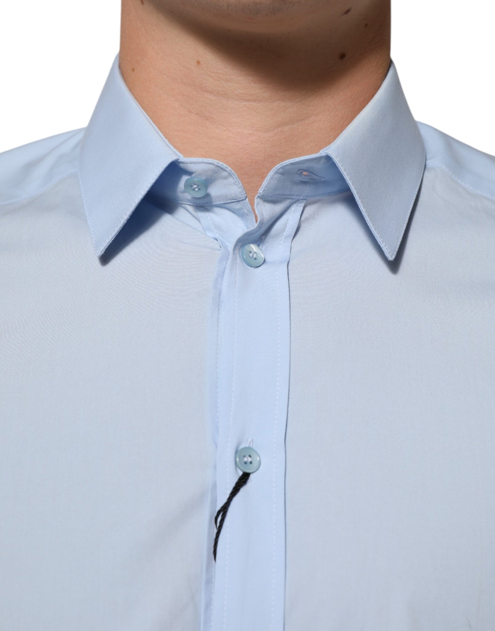 A light blue cotton dress shirt with gold buttons and a collar