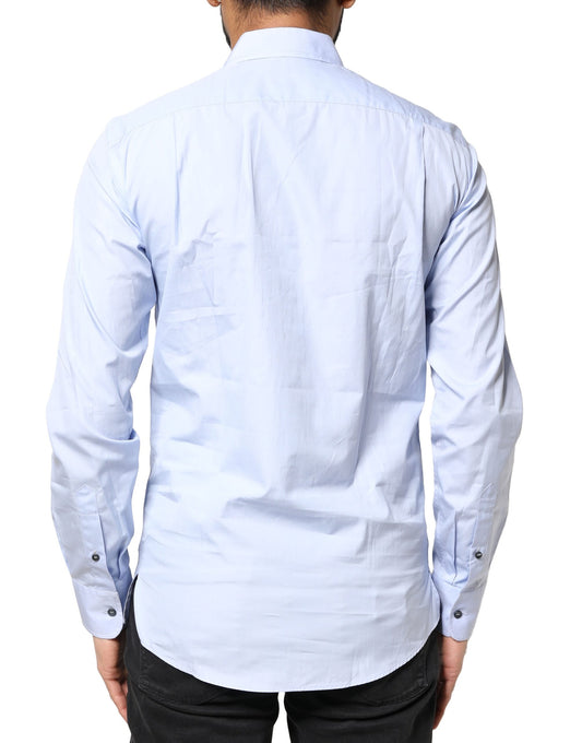 A light blue cotton dress shirt with long sleeves, featuring a collar and button-down front