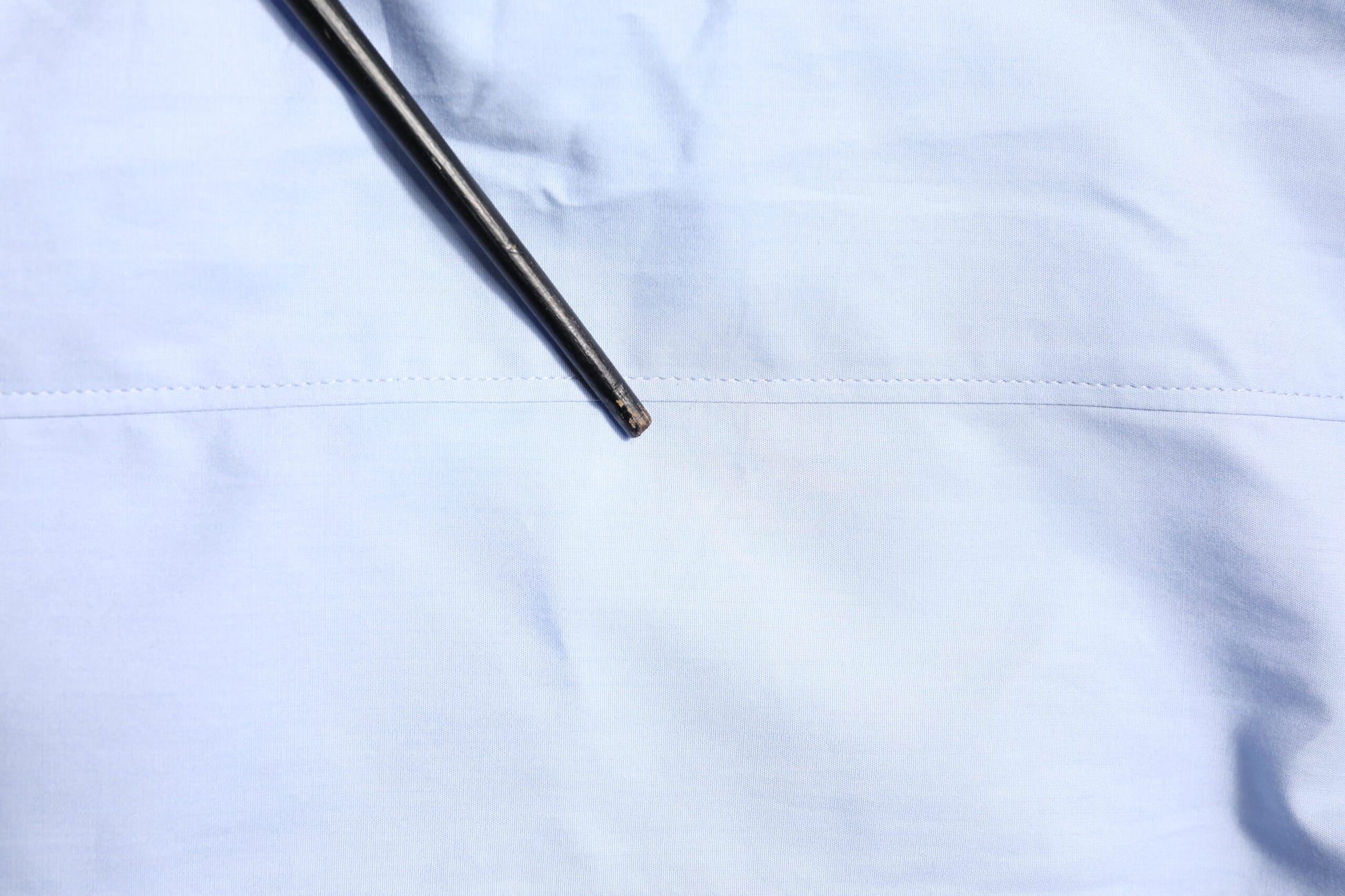 A light blue cotton dress shirt with long sleeves, featuring a button-up front and a collar