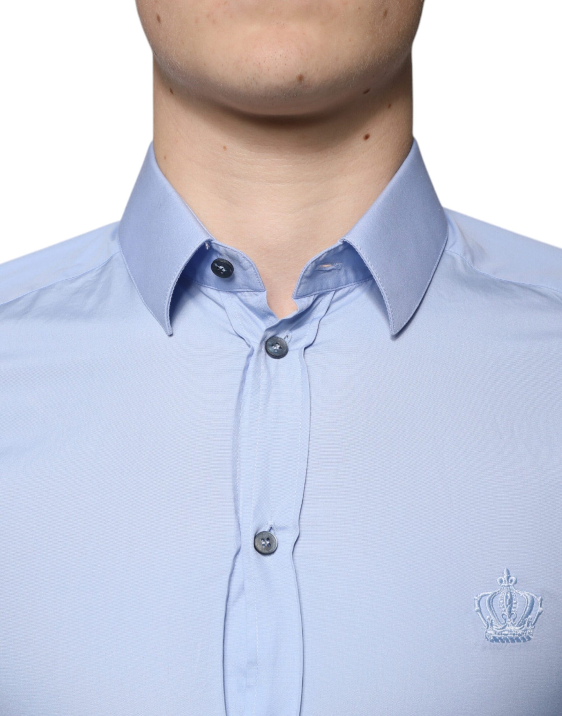 A light blue cotton slim fit dress shirt with a gold emblem