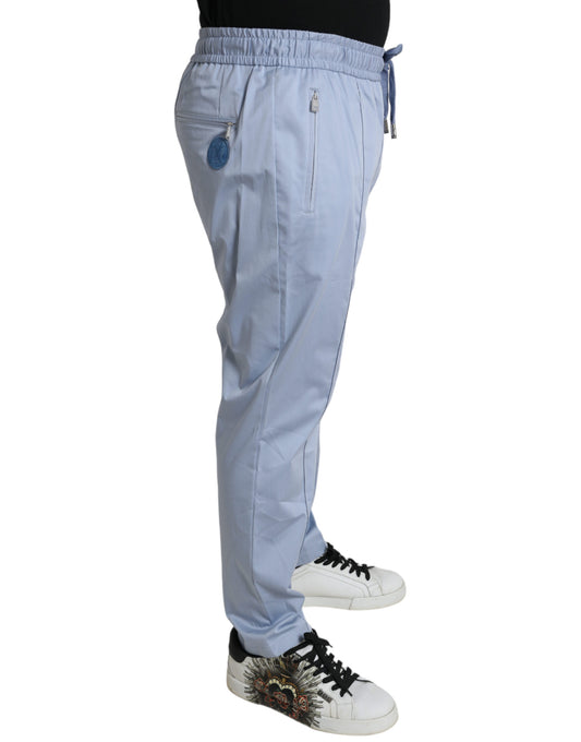 Pair of light blue pants worn by a person standing against white background
