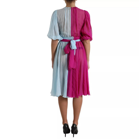 A light blue silk two tone midi dress with a pink belt and bow, worn by a mannequin