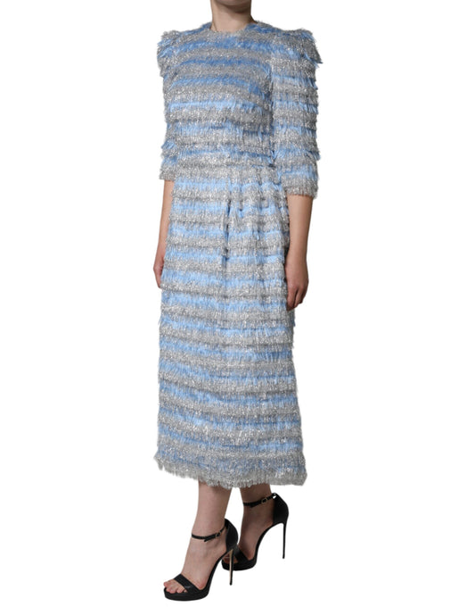 A woman wearing a light blue and silver jacquard midi dress. The dress features an A-line silhouette with a f