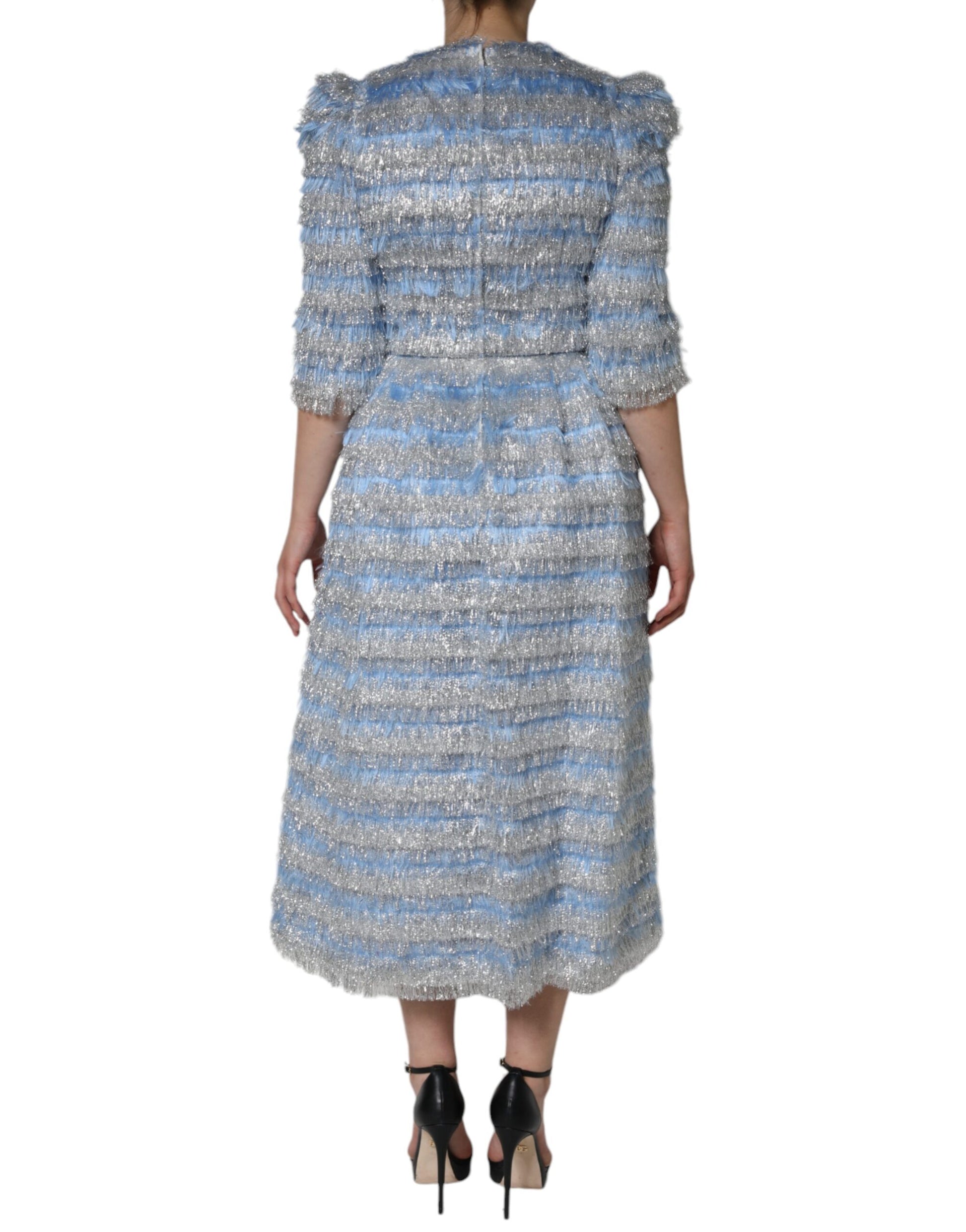 A midi dress with a light blue and silver jacquard pattern. It features a fitted bodice, long sleeves, and an