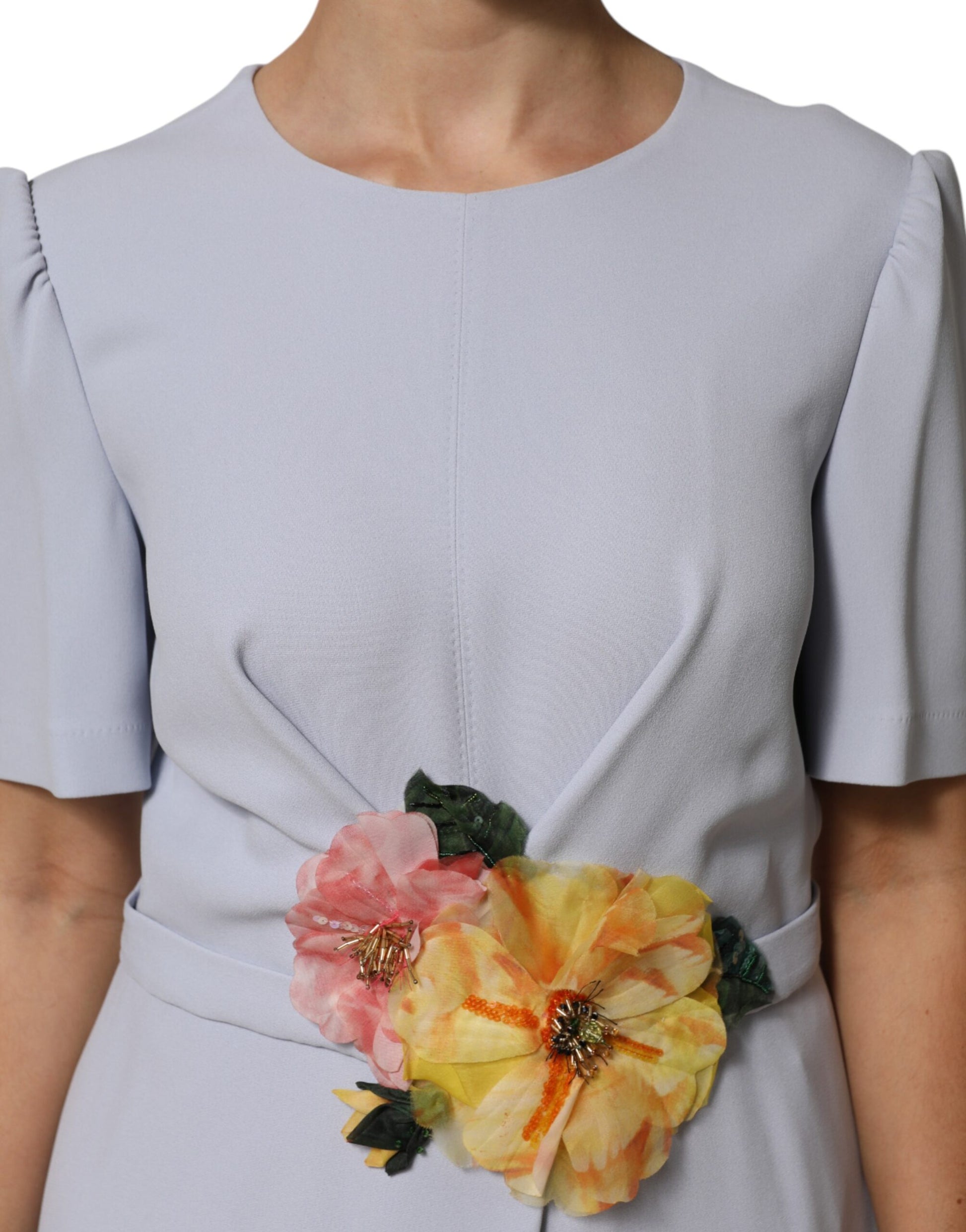 A light blue dress with a floral applique on the front, made of viscose blend fabric