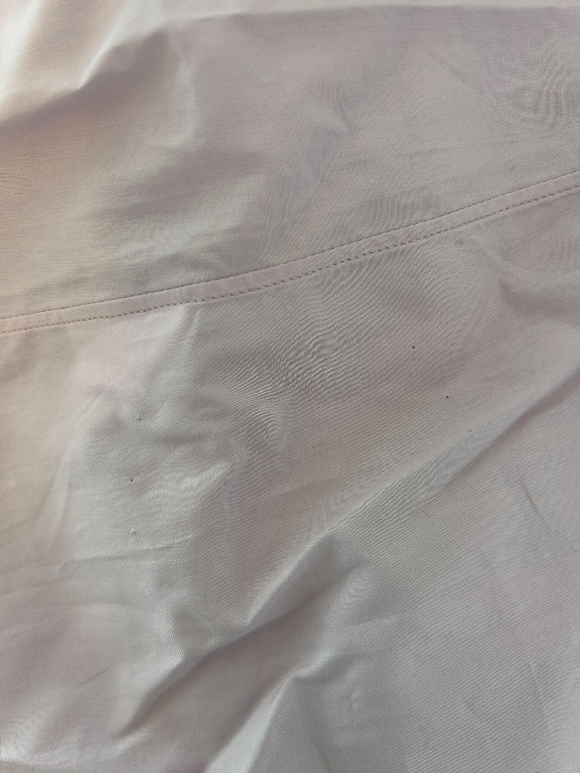 A light pink cotton formal dress shirt with a gold design