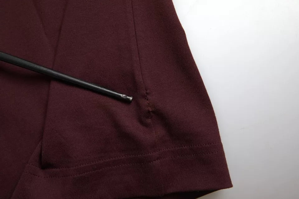 A maroon garment with a black pen resting on its surface