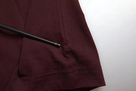 A maroon garment with a black pen resting on its surface