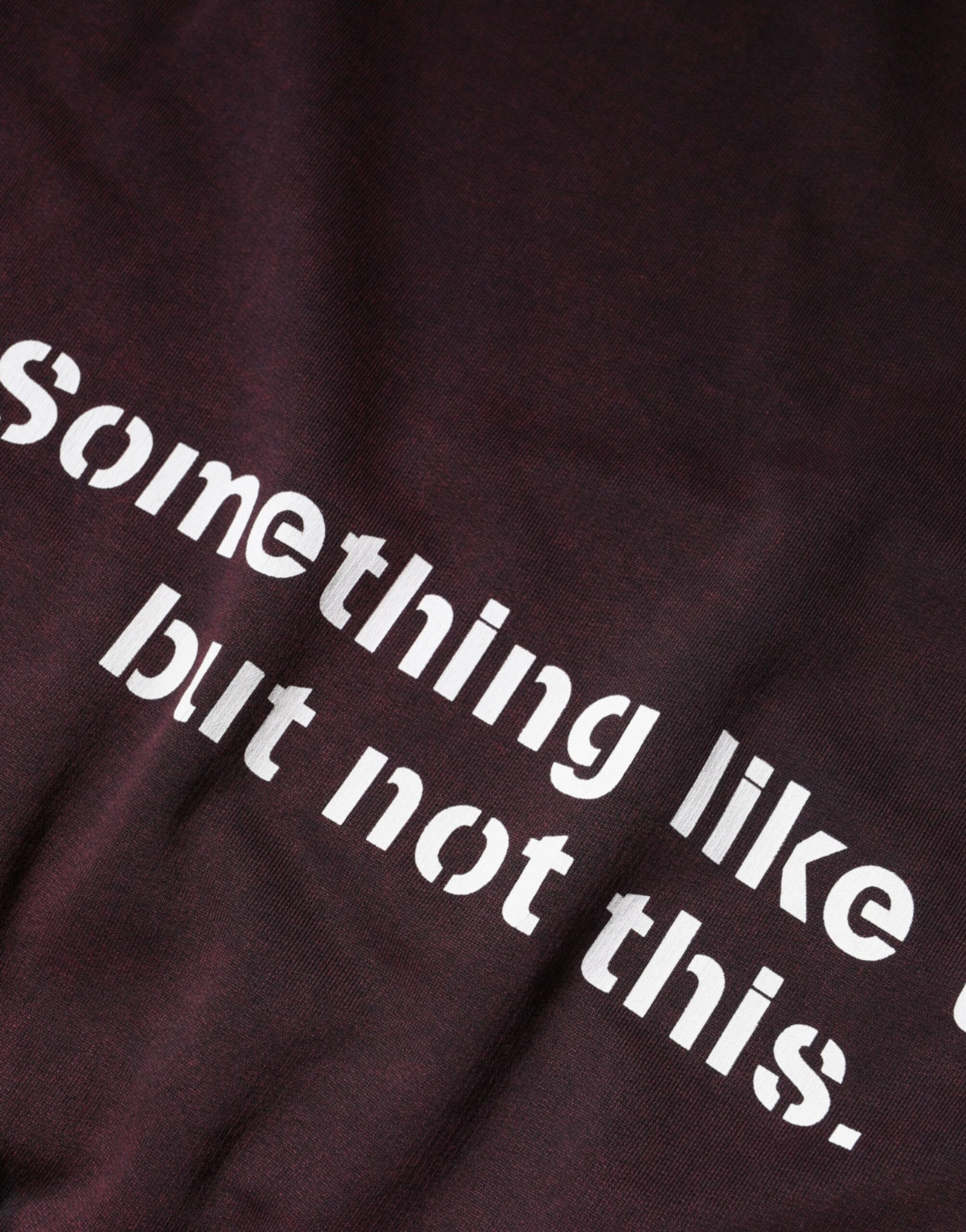 A dark fabric item with white lettering that reads "something like this but not this