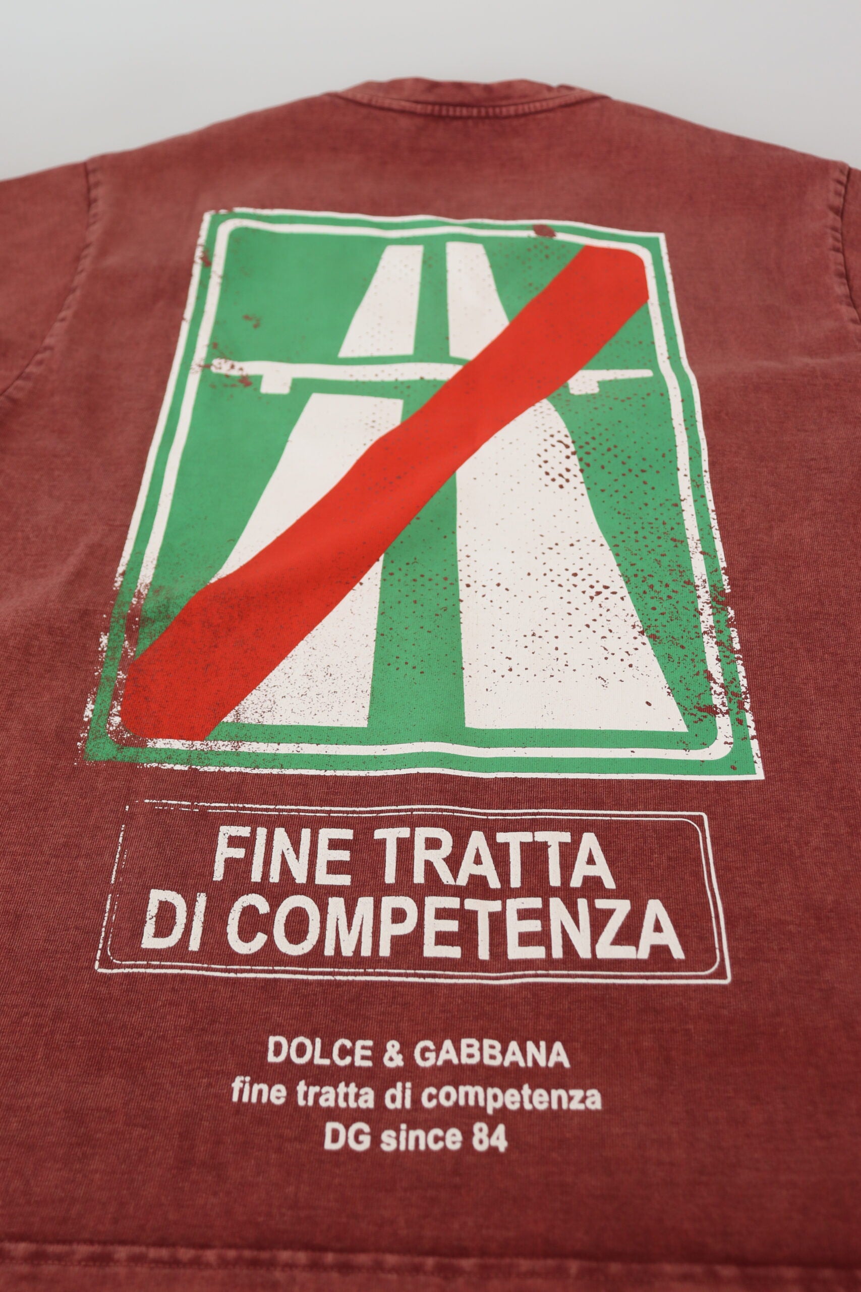 Red jacket with white road sign graphic and Italian phrase