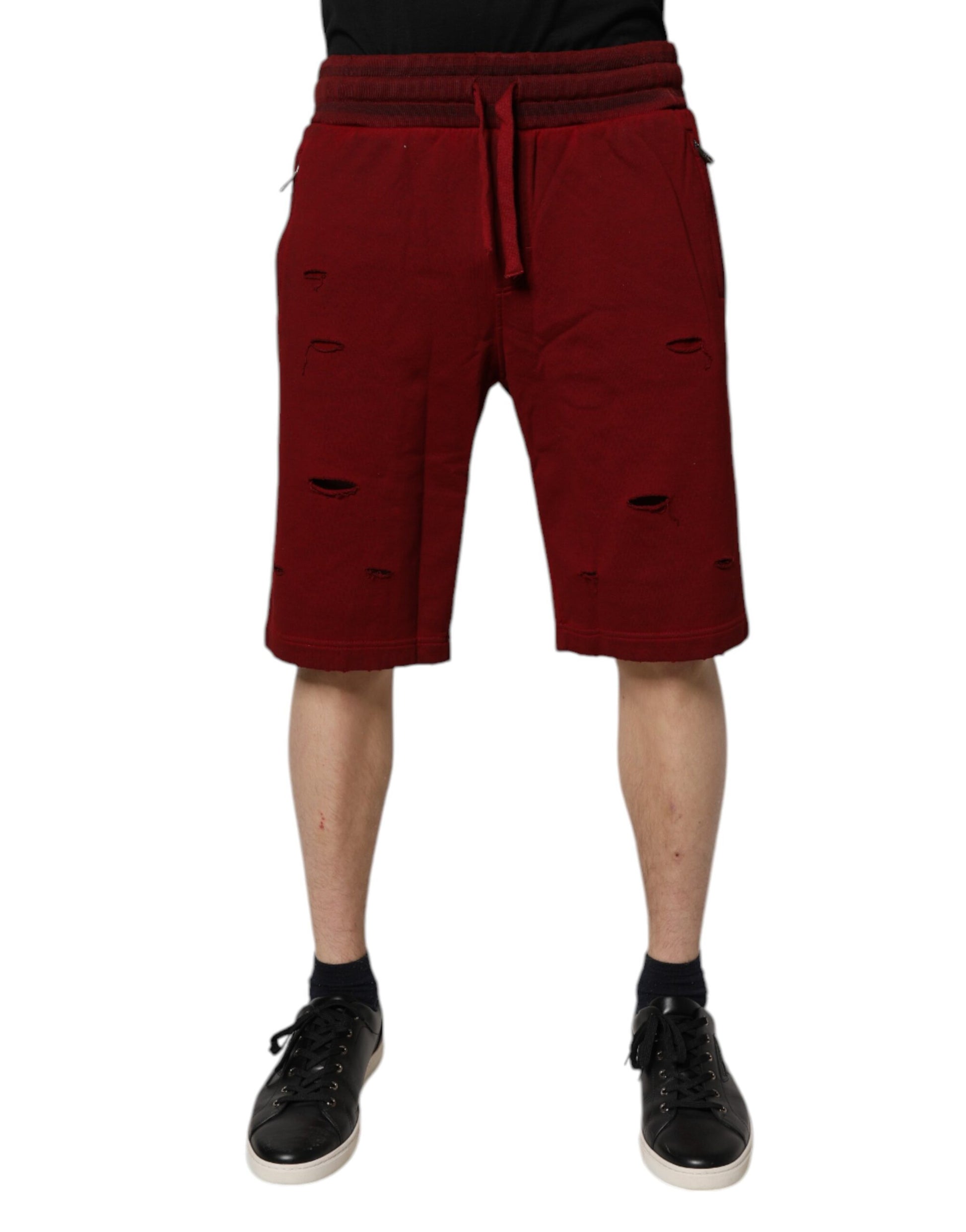 Red shorts with holes, part of a man's outfit