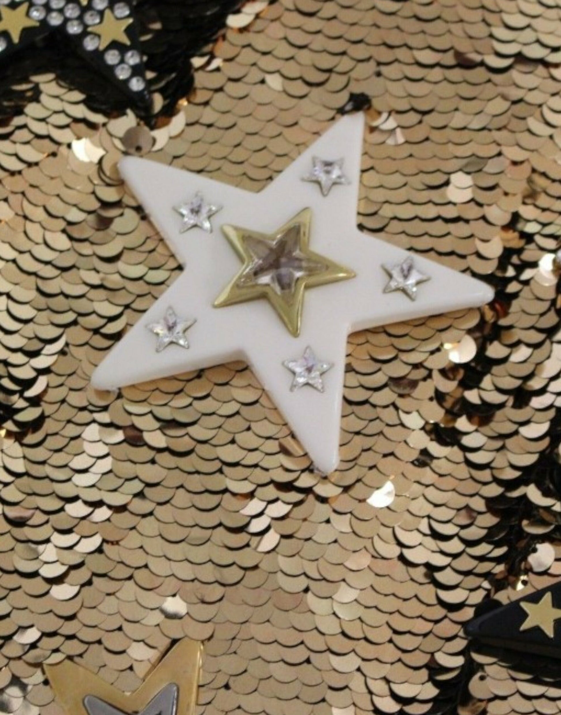 Shiny gold star shaped pendant with clear gemstones