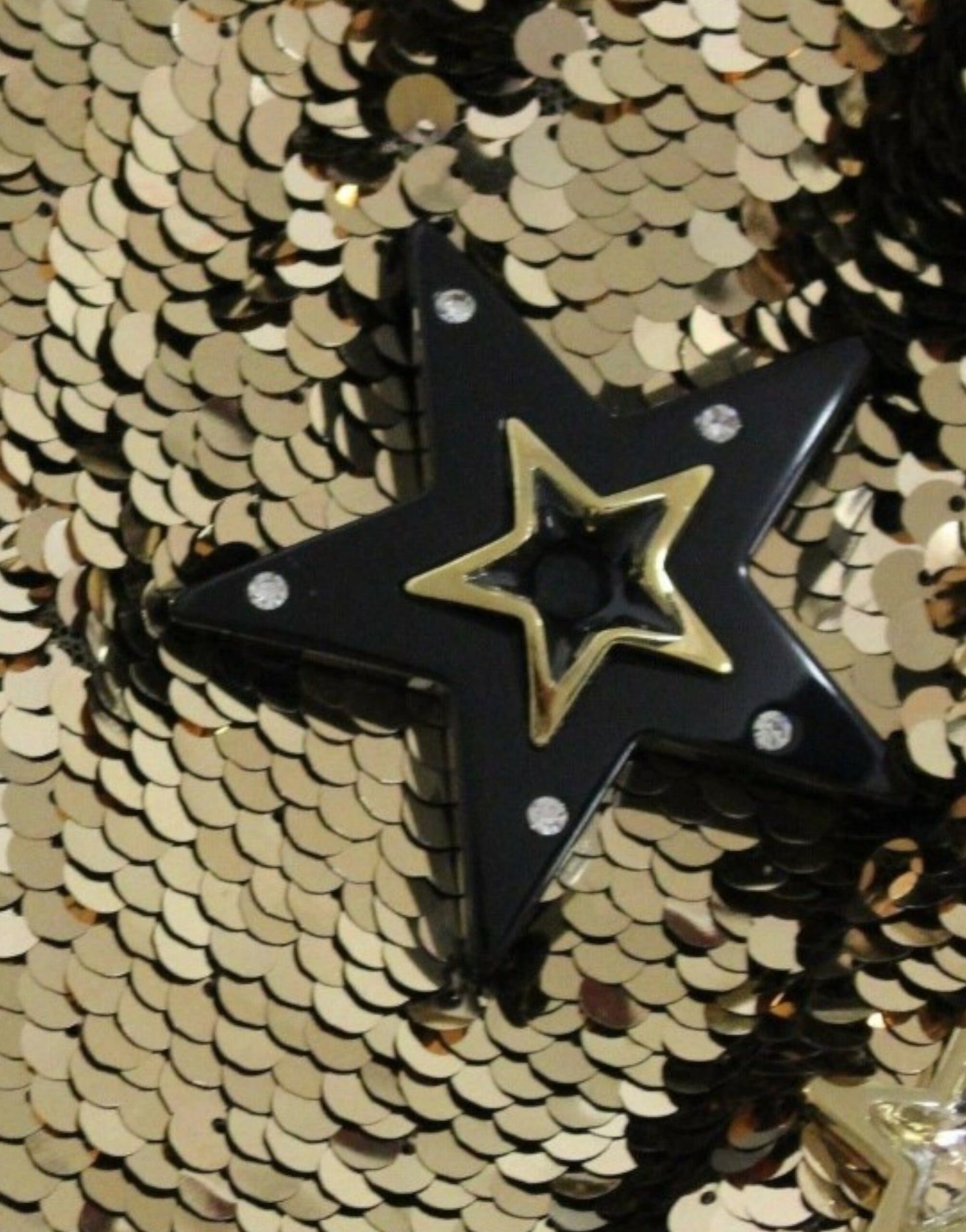 Black star shaped brooch with gold star in center