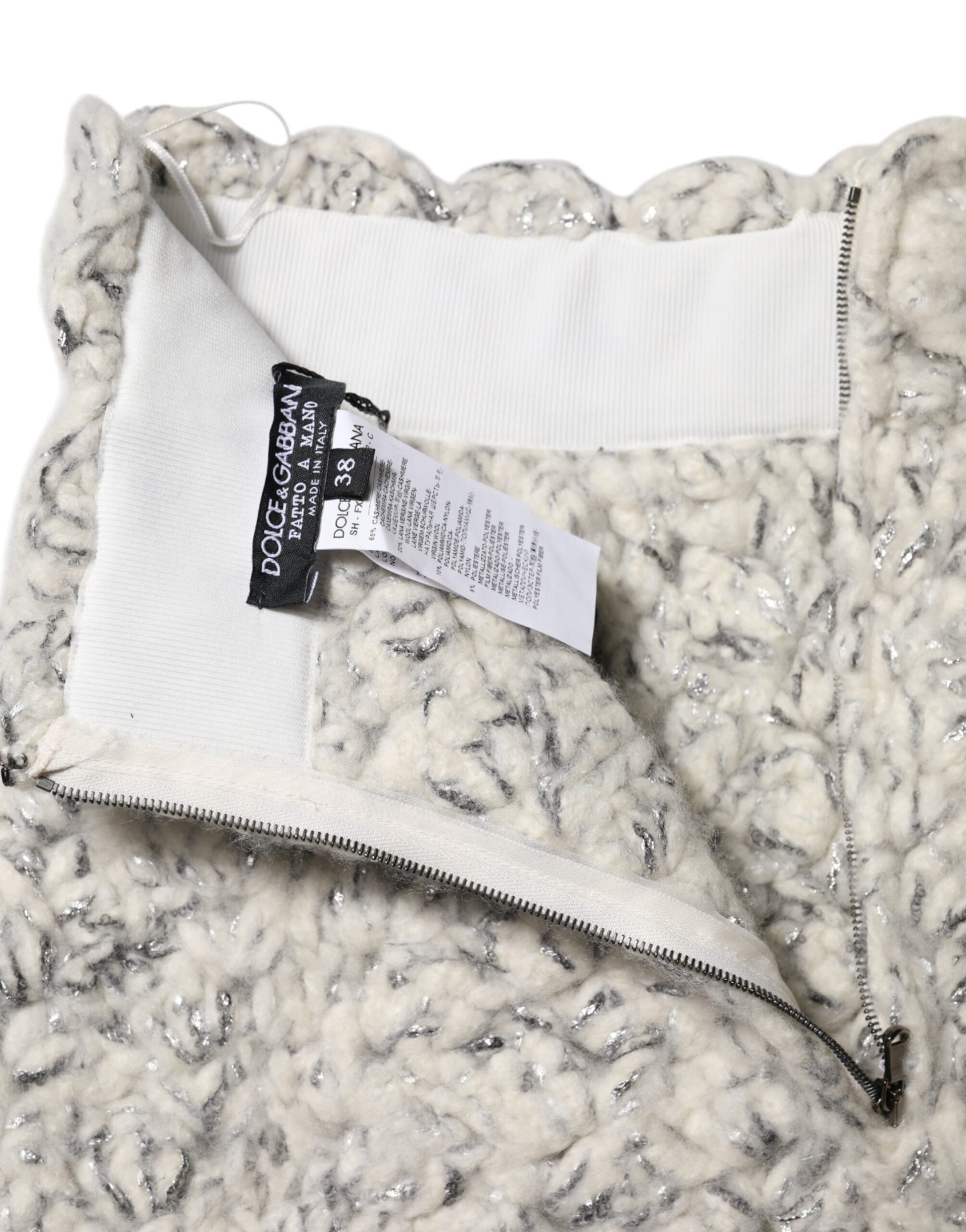 The jacket is white and gray with a zippered front