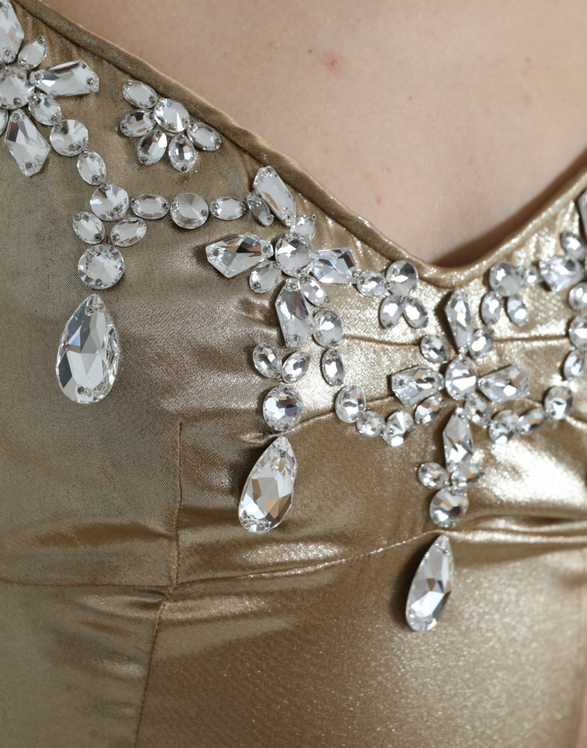 A gold dress with crystal embellishments on the bodice and sleeves