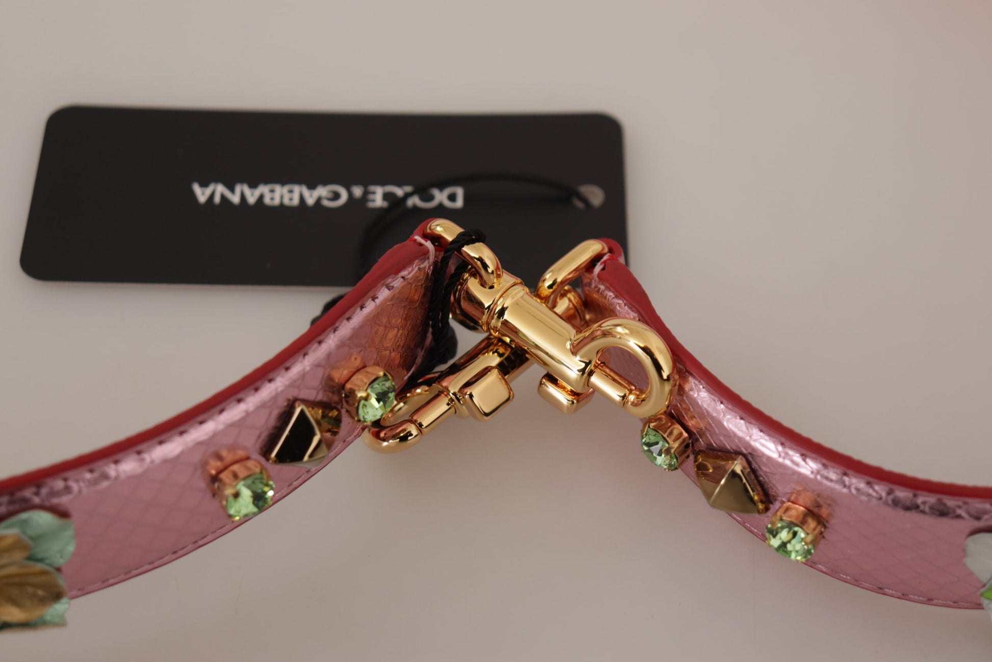 Pink belt with gold buckle and green stones