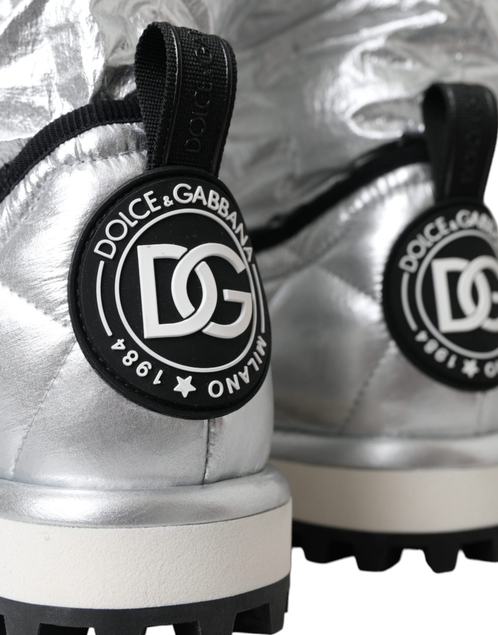 Silver sneakers with black laces and a logo on the side