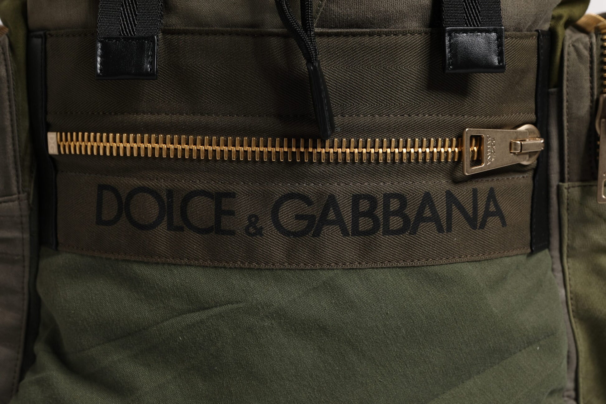 Green backpack with gold zipper pulls