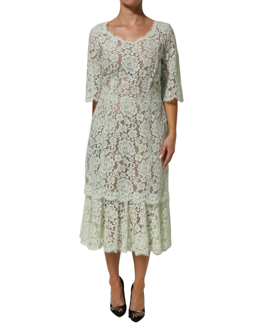 A woman wearing a mint green lace trim midi dress with floral pattern