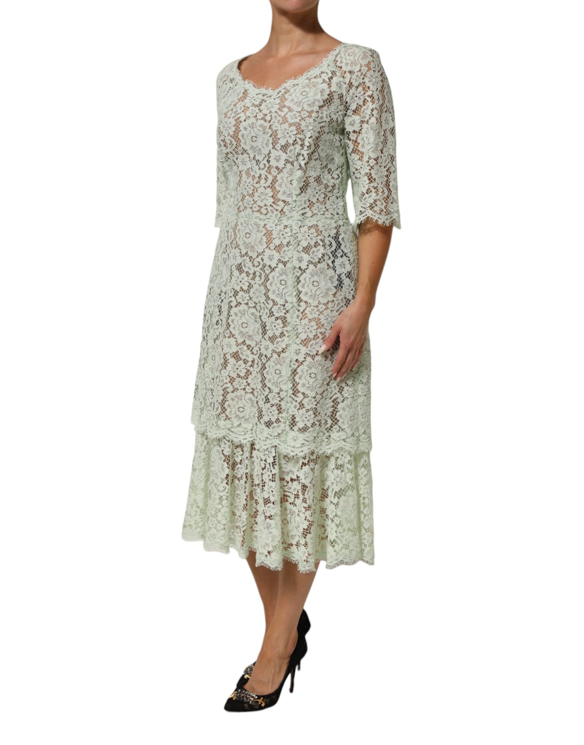 A woman wearing a mint green floral lace trim midi dress by Dolce & Gabbana