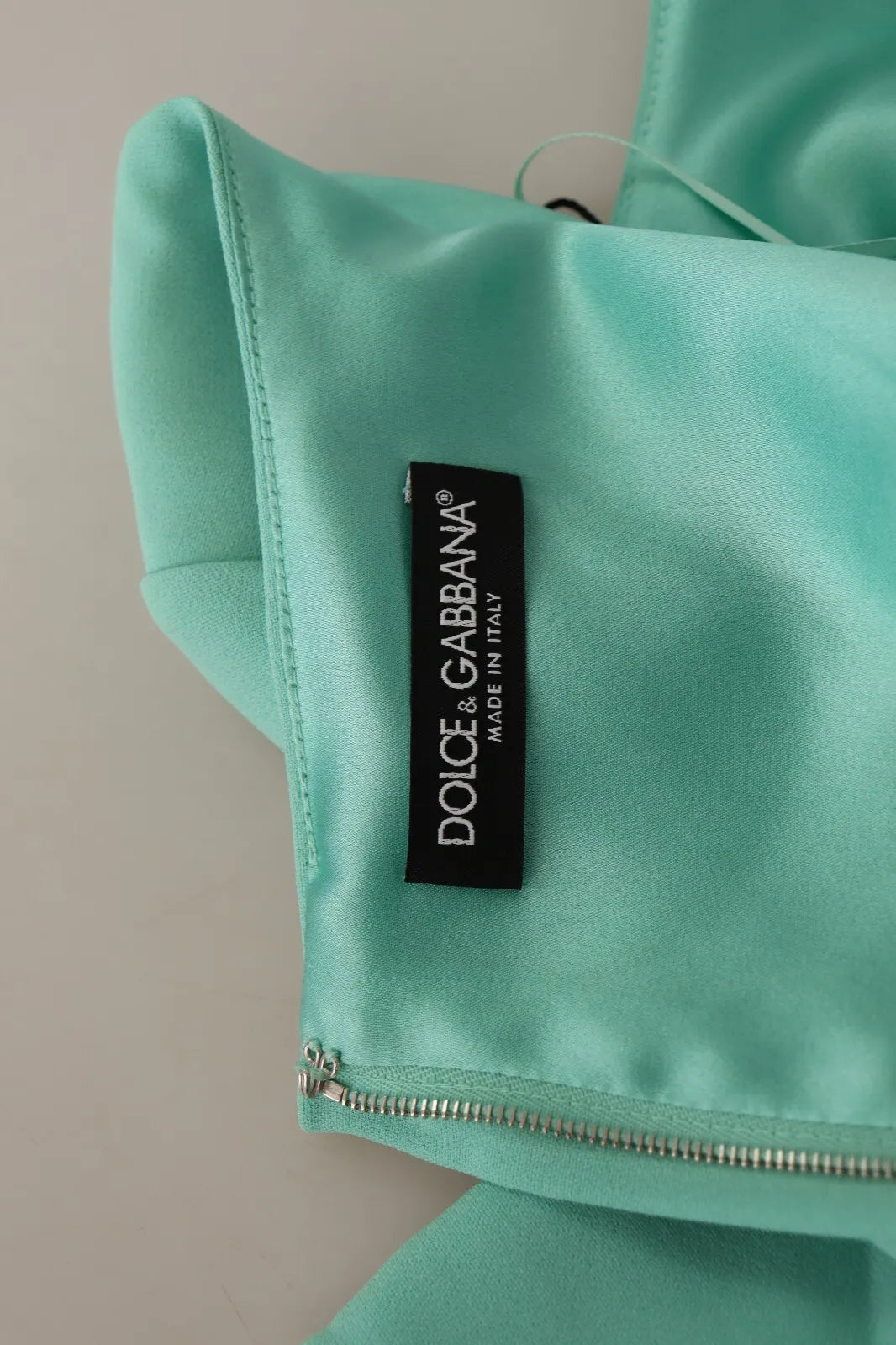 A mint green sheath dress with a square neckline and zipper closure